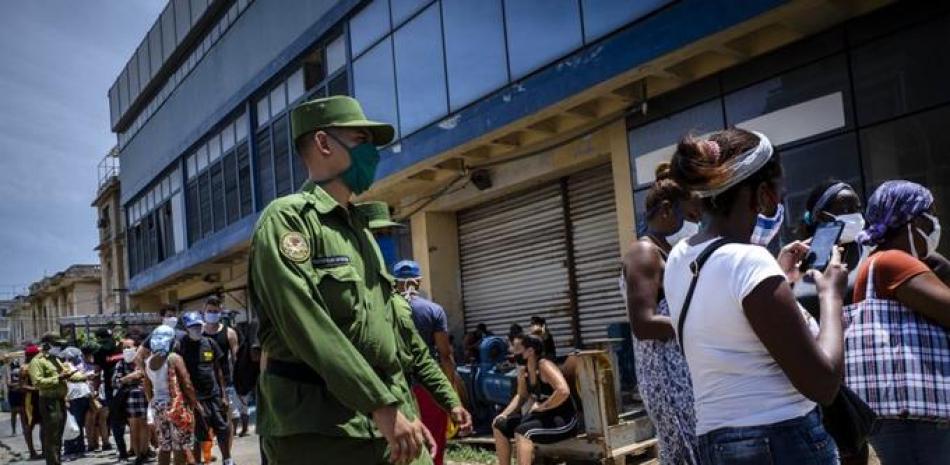 Un soldado patrulla afuera de una tienda de alimentos administrada por el gobierno donde los compradores esperan en fila para ingresar en La Habana, Cuba, el martes 19 de mayo de 2020.

Foto: AP / Ramón Espinosa