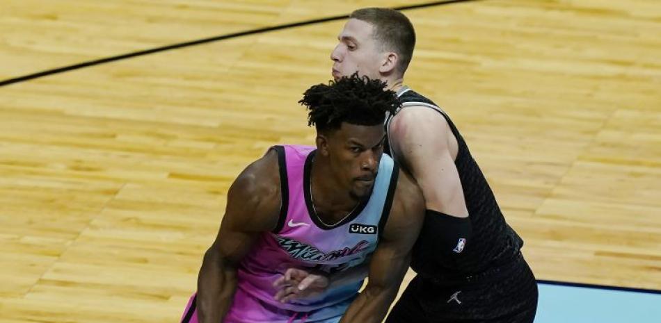 Jimmy Butler, de los Heat de Miami, maneja el balón ante la defensa de Kyle Guy, de los Kings de Sacramento, en acción del partido del sábado por la noche en la NBA.