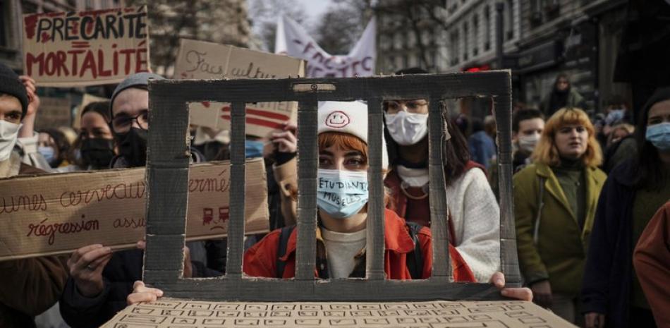 Estudiantes protestan en Lyon, Francia, el martes 26 de enero de 2021 para demandar apoyos para los trabajadores afectados por las restricciones adoptadas en respuesta a la pandemia de coronavirus. (AP Foto/Laurent Cipriani)