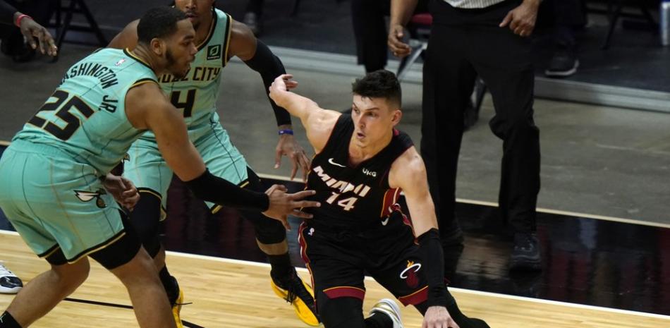 El base de los Miami Heat, Tyler Herro (14), supera al alero de los Charlotte Hornets, PJ Washington (25), durante la primera mitad del juego de baloncesto de la NBA, el lunes 1 de febrero de 2021, en Miami.