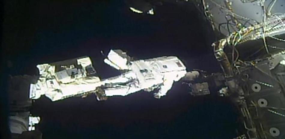 Esta captura de fotogramas de video de la NASA TV muestra al astronauta Mike Hopkins durante una instalación, mientras los astronautas Hopkins y Victor Glover terminan un esfuerzo de cuatro años para actualizar el sistema de energía de la Estación Espacial Internacional durante una caminata espacial el 1 de febrero de 2021. Folleto / NASA TV / AFP