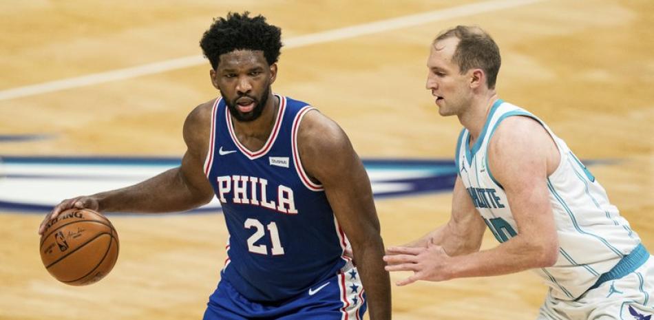 El pívot de los Philadelphia 76ers, Joel Embiid (21), es protegido por el pívot de los Charlotte Hornets, Cody Zeller (40), durante la primera mitad de un partido de baloncesto de la NBA en Charlotte, Carolina del Norte, este miércoles.