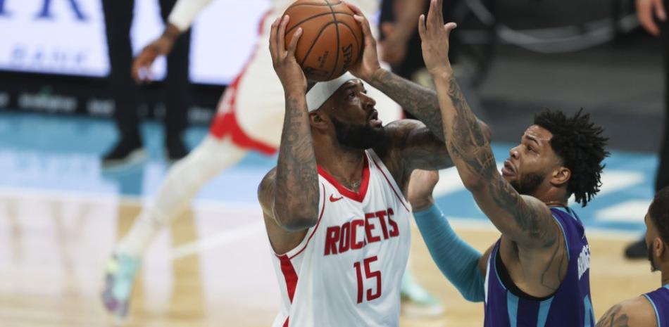 El pívot de los Houston Rockets, DeMarcus Cousins ??(15), dispara sobre el alero de los Charlotte Hornets Miles Bridges en la primera mitad de un juego de baloncesto de la NBA en Charlotte, Carolina del Norte.