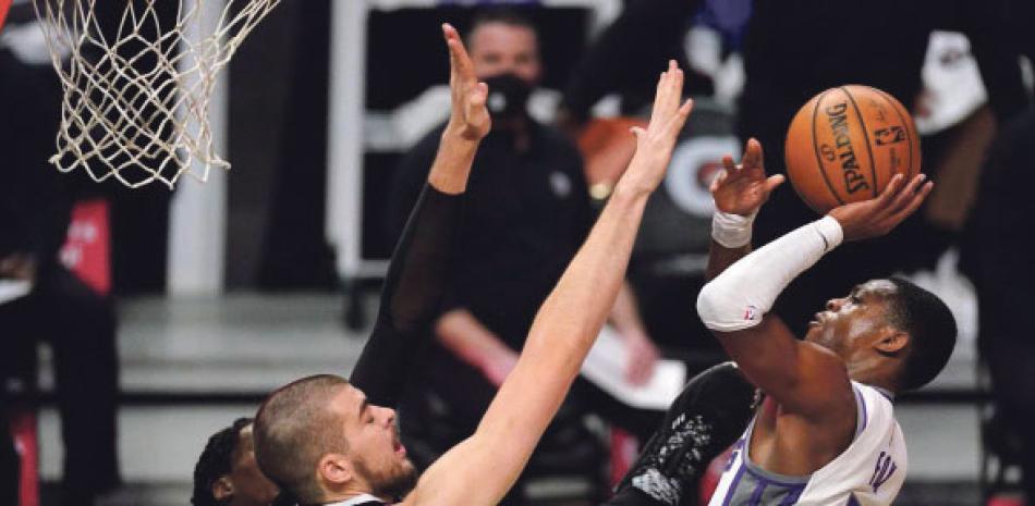 De’Aaron Fox, de Sacramento, lanza el balón mientras lo defiende Ivica Zubac, de los Clippers, en el partido de ayer en el baloncesto de la NBA.