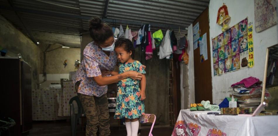 Elena Escalante ayuda a su hija Zaii, de tres años, a prepararse para un concurso de belleza casero, en el vecindario de Antimano, en Caracas, Venezuela, el 5 de febrero de 2021.

Foto: AP/ Ariana Cubillos