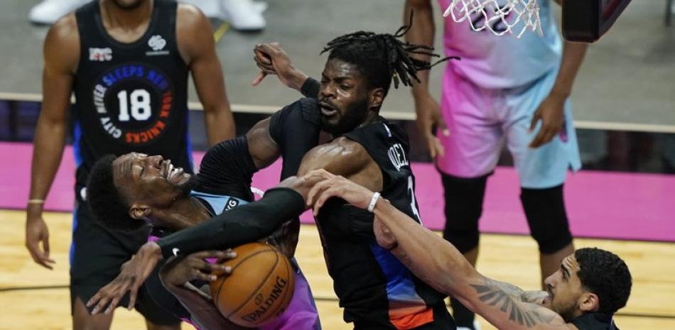 El pívot de los New York Knicks, Nerlens Noel (3) y el alero Obi Toppin (1) bloquean un tiro a la canasta del pívot de los Miami Heat Bam Adebayo (13) durante la segunda mitad de un partido de baloncesto de la NBA, este martes.