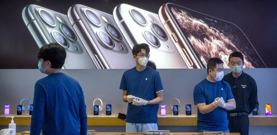 Los empleados usan máscaras faciales mientras están parados en una Apple Store reabierta en Beijing.

Foto: AP/ Mark Schiefelbein