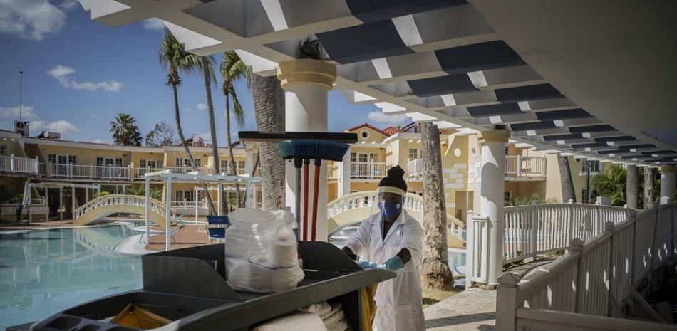 Con una máscara contra la propagación del nuevo coronavirus, una empleada doméstica va a limpiar las habitaciones del Hotel Comodoro en La Habana, Cuba, el jueves 11 de febrero de 2021.

Foto: AP/ Ramón Espinosa)