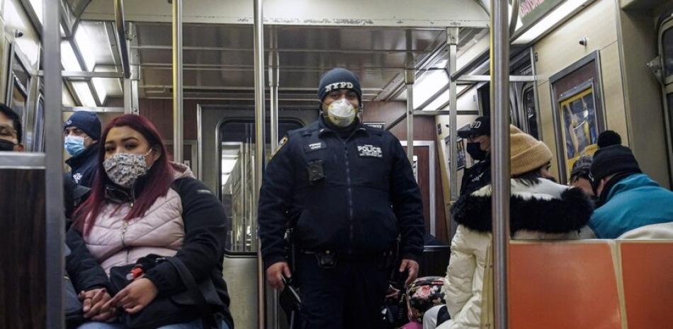 Un policía patrulla en un tren de la línea A del metro en dirección a Inwood, después de que la policía desplegara 500 agentes adicionales en la red de metro tras varios ataques mortales. (The Associated Press)
