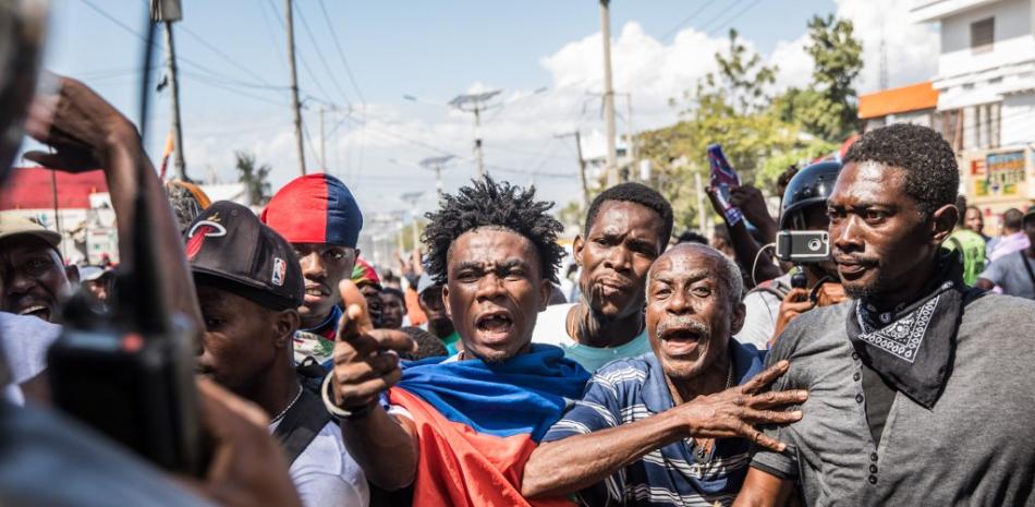 Manifestantes se enfrentan a los agentes de policía mientras marchan en Puerto Príncipe el 14 de febrero de 2021 para protestar contra el gobierno del presidente Jovenel Moise. Valerie Baeriswyl / AFP