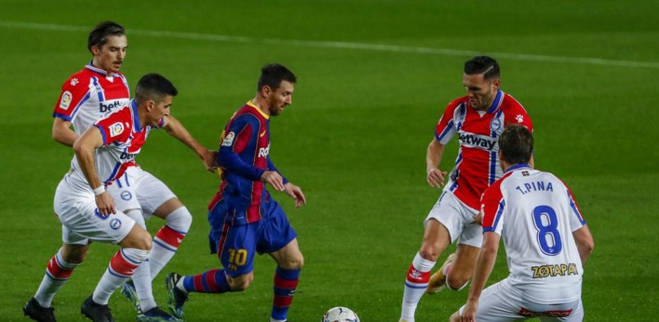 Lionel Messi (centro) del Barcelona avanza con el balón rodeado por jugadores de Alavés durante el partido de la Liga española, el sábado 13 de febrero de 2021, en Barcelona.