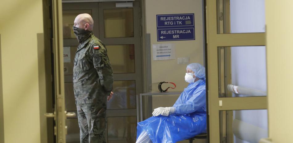 Un soldado y una enfermera polacos esperan en un hospital en Cracovia, Polonia, el viernes 12 de febrero de 2021, durante la vacunación de maestros contra el coronavirus con la vacuna elaborada por AstraZeneca.

Foto: AP/ Czarek Sokolowski