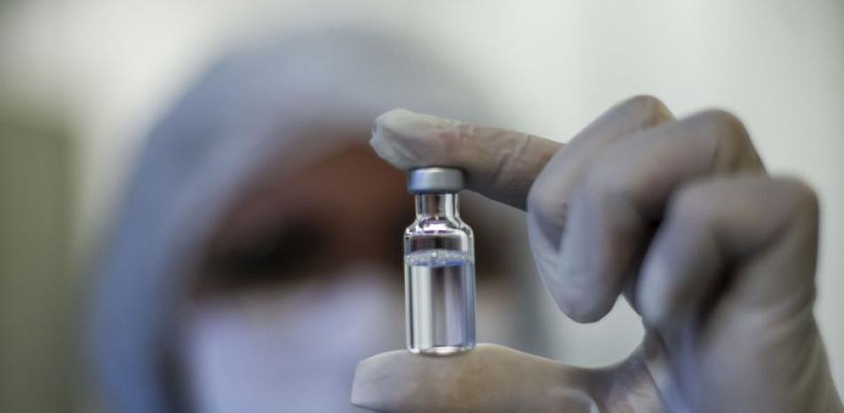Una trabajadora muestra un vial de la vacuna contra el coronavirus desarrollada por AstraZeneca y la Universidad de Oxford, y producida por la Fundación Fiocruz en Río de Janeiro, Brasil, el 12 de febrero de 2021.

Foto: AP/ Bruna Prado