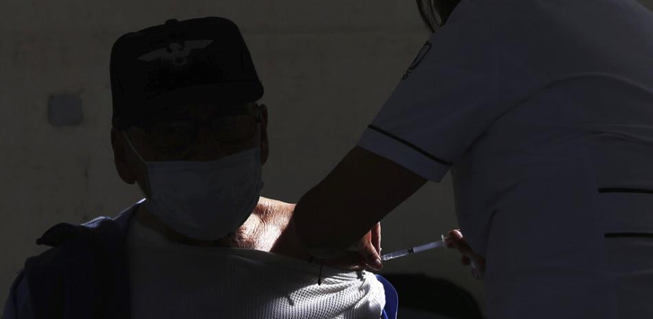 Un hombre recibe la vacuna contra el coronavirus en el distrito de Magdalena Contreras en la Ciudad de México, el martes 16 de febrero de 2021, mientras el país empieza a vacunar a las personas mayores de 60 años contra el virus.

Foto: AP/Marco Ugarte