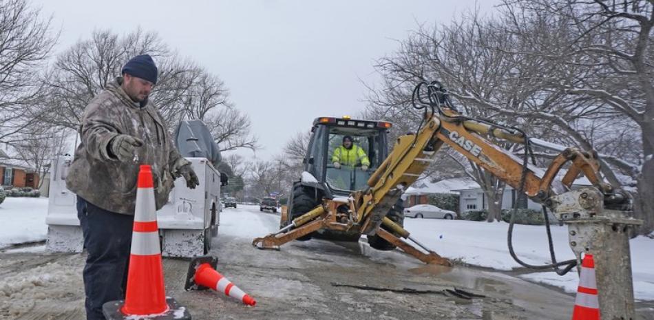 Trabajadores de la ciudad de Richardson se preparan para laborar en un tubo de distribución de agua que se rompió debido al intenso frío, el miércoles 17 de febrero de 2021, en Richardson, Texas. (AP Foto/LM Otero)