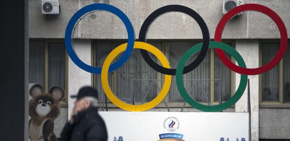 En imagen de archivo del 28 de noviembre de 2019, los anillos olímpicos y un modelo de Misha, el osezno, mascota de los Juegos Olímpicos de Moscú 1980, izquierda, son exhibidos frente al edificio del Comité Olímpico Ruso, en Moscú, Rusia.