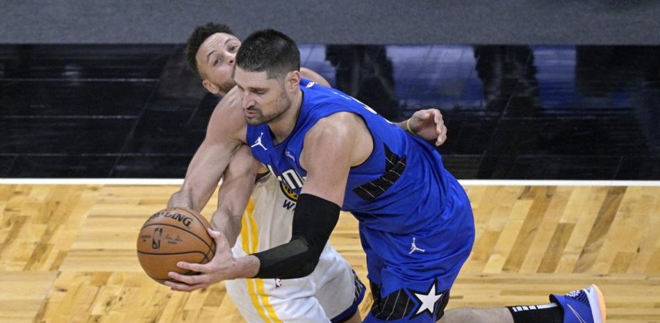 El centro de los Orlando Magic, Nikola Vucevic, a la derecha, recibe una falta del escolta de los Golden State Warriors, Stephen Curry (30), durante la segunda mitad de un juego de baloncesto de la NBA, el viernes .