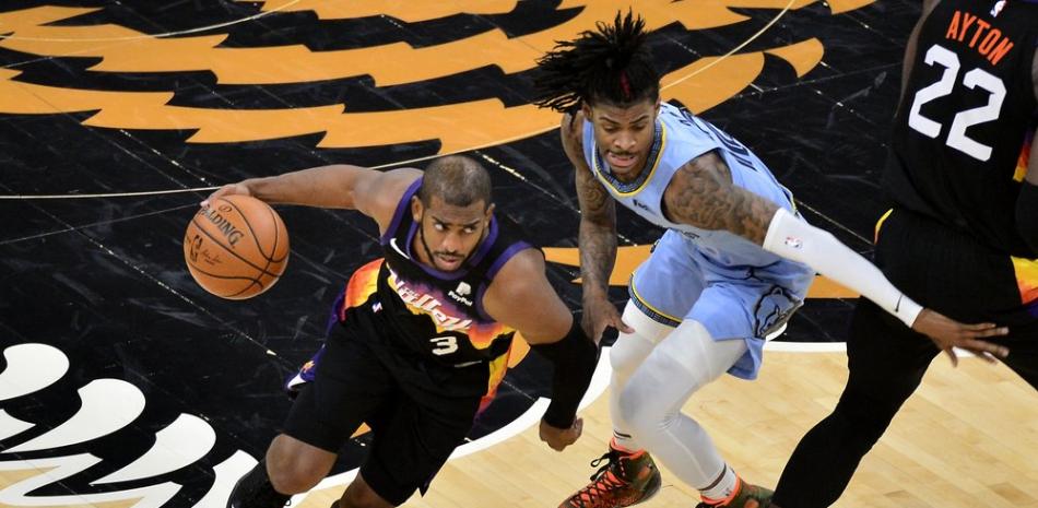 El escolta de los Phoenix Suns, Chris Paul (3), impulsa contra el escolta de los Grizzlies de Memphis, Ja Morant, en la primera mitad de un partido de baloncesto de la NBA este sábadO.
