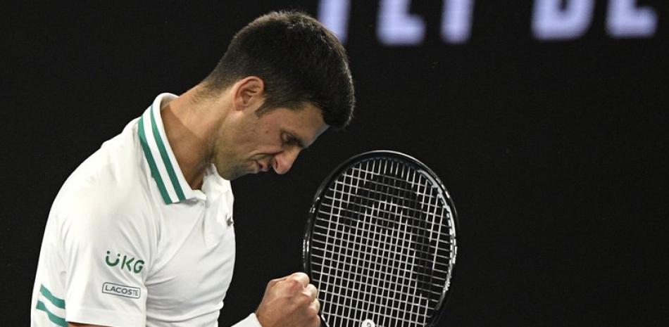 El tenista serbio Novak Djokovic reacciona tras ganar un punto contra el tenista ruso Daniil Medvedev , en la final masculina del Abierto de Australia en Melbourne, Australia, este domingo.