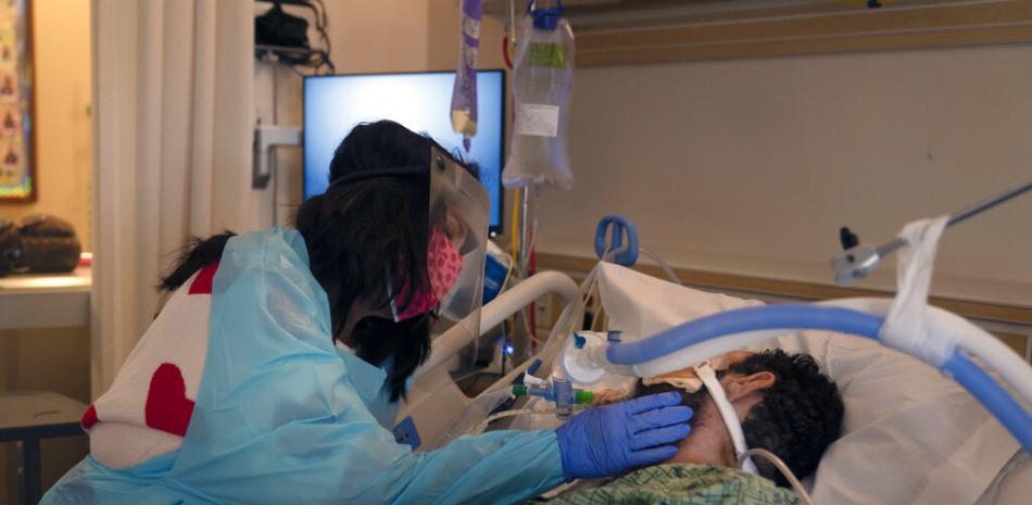 Patty Trejo, de 54 años, toca el rostro de su esposo intubado el lunes 15 de febrero de 2021 en una unidad de COVID-19 en el Centro Médico St. Jude, en Fullerton, California.

Foto: AP/ Jae C. Hong