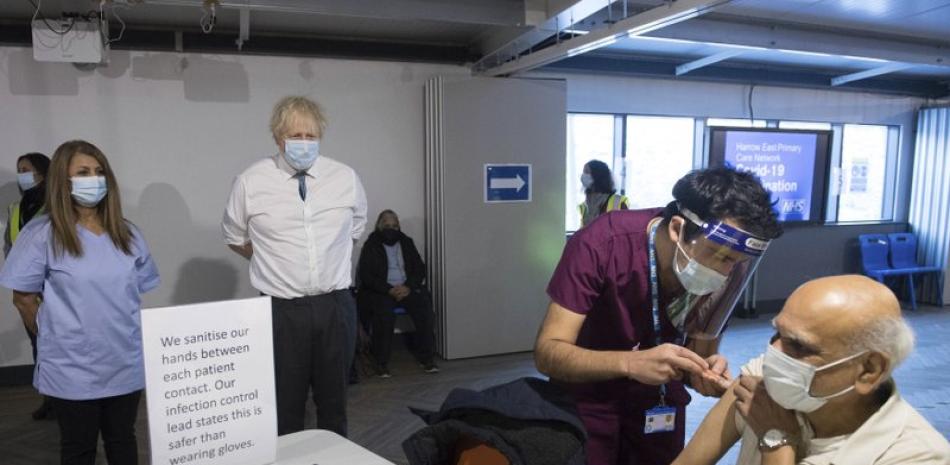 Fotografía de archivo del 25 de enero de 2021 del primer ministro británico, Boris Johnson, mientras observa cómo un enfermero aplica una dosis de la vacuna de Oxford AstraZeneca contra el COVID-19 durante una visita a Barnet FC, en Londres. (Stefan Rousseau/Fotografía de Pool vía AP, Archivo)