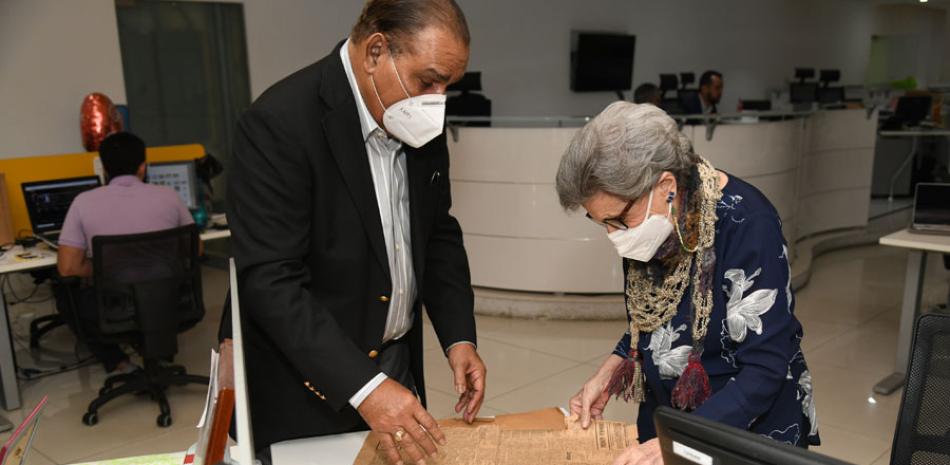 Doña Carmen muestra al director del Listín Diario, Miguel Franjul, la edición de este periódico donde se anunció su nacimiento hace 88 años. JULIO CÉSAR PEÑA /