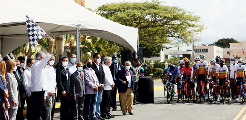 El presidente Luis Abinader otorga el banderazo de honor que dejó inaugurada la Vuelta Ciclista. Observan varias de las personas que lo acompañaron en la actividad.