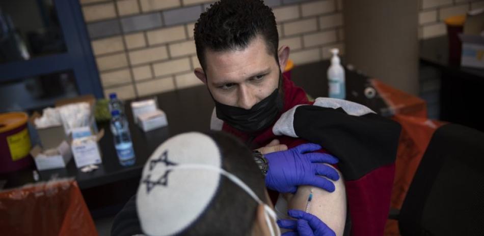 Médicos israelíes aplican la vacuna contra el coronavirus a un palestino en el cruce Qalandia, entre Ramala y Jerusalén, el 23 de febrero del 2021. (AP Photo/Oded Balilty)