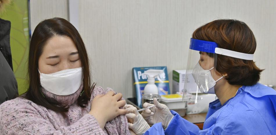 Una empleada en una residencia de ancianos (izquierda) recibe la primera dosis de la vacuna contra el coronavirus desarrollada por AstraZeneca y la Universidad de Oxford, en un centro de atención sanitaria de Seúl, el 26 de febrero de 2021.

Foto: Jung Yeon-je /AP