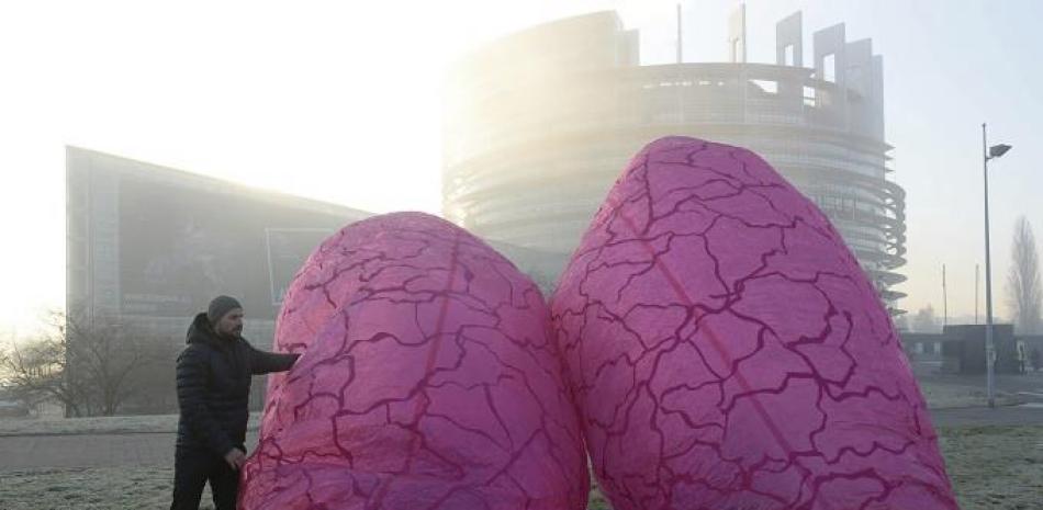 Un miembro de la Asociación Alemana de Protección de la Naturaleza (NABU) coloca unos pulmones gigantes simbólicosa en las inmediaciones del Parlamento Europeo en Estrasburgo (Francia). EFE/Patrick Seeger