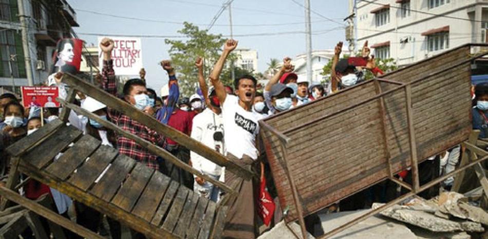 Manifestantes corean lemas ante la llegada de la policía durante una protesta contra el golpe militar en Mandalay. AP