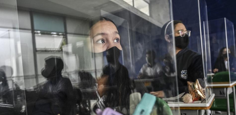 Los estudiantes participan en una clase montada con pantallas protectoras en la Escuela Pública Antonio José Sucre, en medio de la pandemia de COVID 19, en Itagüí, Colombia, el 25 de febrero de 2021.

Foto: JOAQUIN SARMIENTO / AFP
