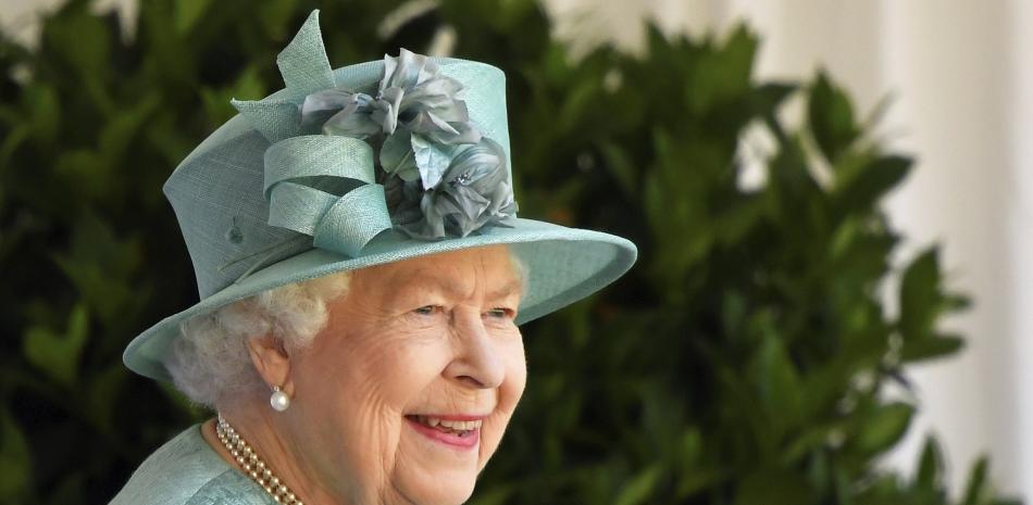 La reina Isabel II observa una ceremonia para marcar su cumpleaños oficial en el Castillo de Windsor, Inglaterra, sábado 13 de junio de 2020. El desfile tradicional de los regimientos con sus banderas fue reducido este año debido al coronavirus.

Foto: Toby Melville/AP