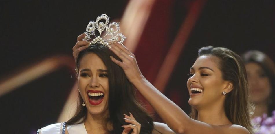La filipina Catriona Gray, a la izquierda, reacciona al ser coronada Miss Universo 2018 por su predecesora, Demi-Leigh Nel-Peters, el 17 de diciembre de 2018 en Bangkok, Tailandia.  (AP Foto/Archivo)