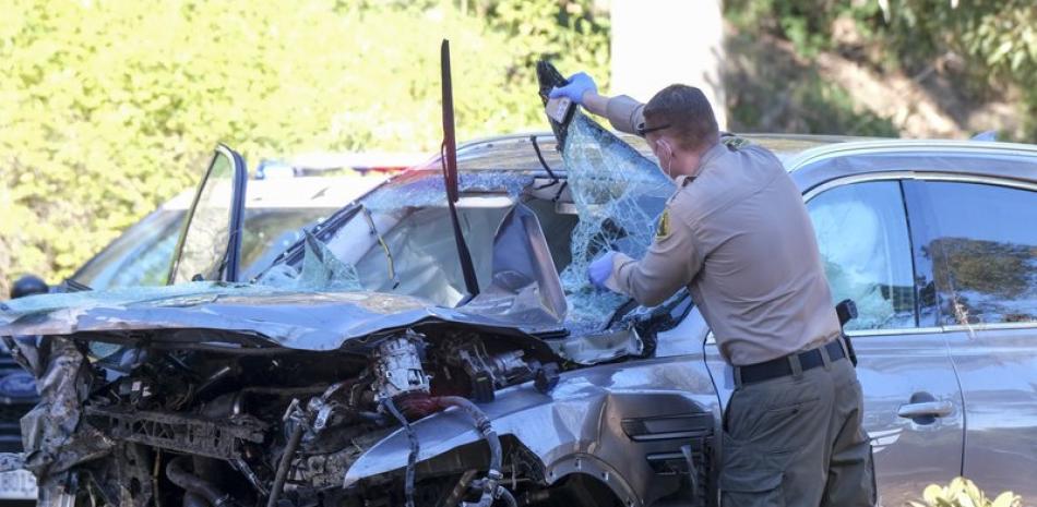 En esta foto del 23 de febrero de 2021, un agente policial observa el vehículo en que se accidentó el golfista Tiger Woods, en Rancho Palos Verdes, un suburbio de Los Ángeles .