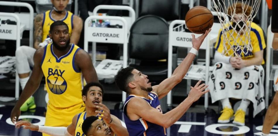Devin Booker, base de los Suns de Phoenix, salta para encestar en el duelo ante los Warriors de Golden State (AP Foto/Rick Scuteri)