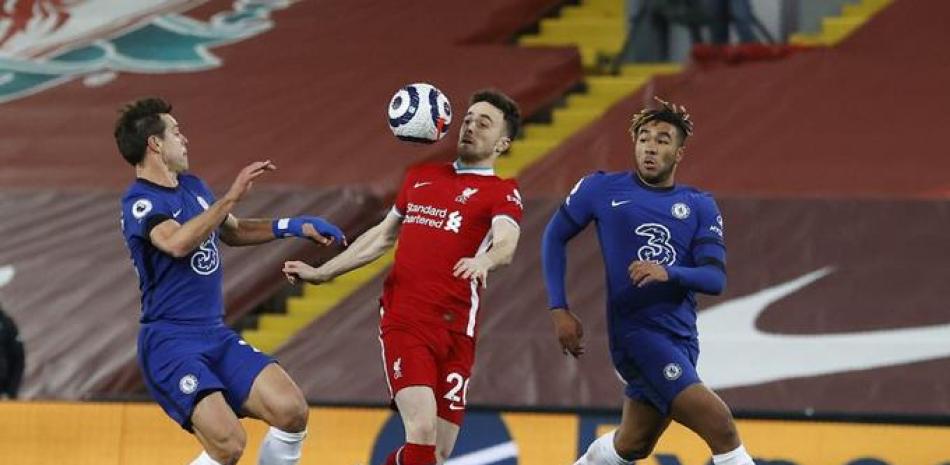 El delantero portugués Diogo Jota, centro, del Liverpool, disputa el balón con el español César Azpilicueta, izquierda, y Reece James, del Chelsea, durante el partido de la Liga Premier en el estadio Anfield de Liverpool, Inglaterra, el jueves 4 de marzo de 2021.