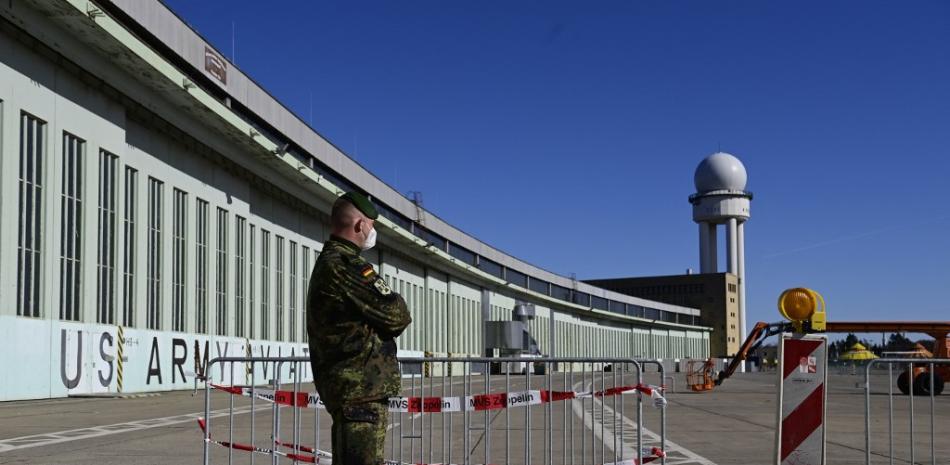 Un soldado de las Fuerzas Armadas Alemanas Bundeswehr se encuentra frente a un nuevo centro de vacunación en el antiguo aeropuerto de Tempelhof en Berlín antes de su apertura el 8 de marzo de 2021.
Tobias Schwarz / AFP / PISCINA