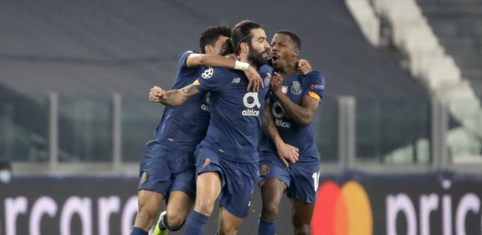 Sergio Oliveira (centro) celebra tras anotar el segundo gol del Porto en el partido contra Juventus en los octavos de final de la Liga de Campeones, el martes 9 de marzo de 2021, en Turín.