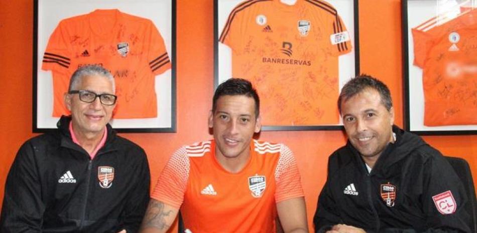 Claudio Chiqui Pérez , Alberto Polanco y Gabriel Fernández , durante la firma de contrato  del jugador con el Cibao FC.