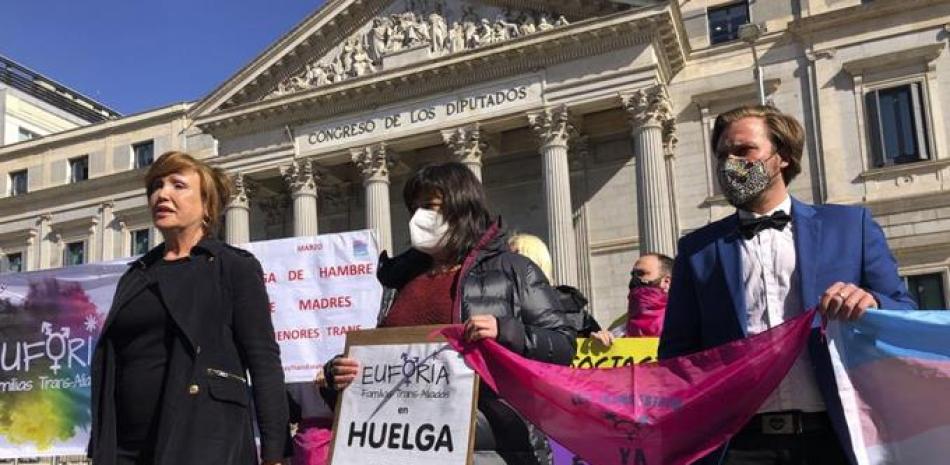 Frente al Congreso de los Diputados, la cámara baja del parlamento español en Madrid, activistas anuncian el inicio de una huelga de hambre por los derechos de los transgénero, miércoles 10 de marzo de 2021. (AP Foto/Aritz Parra)