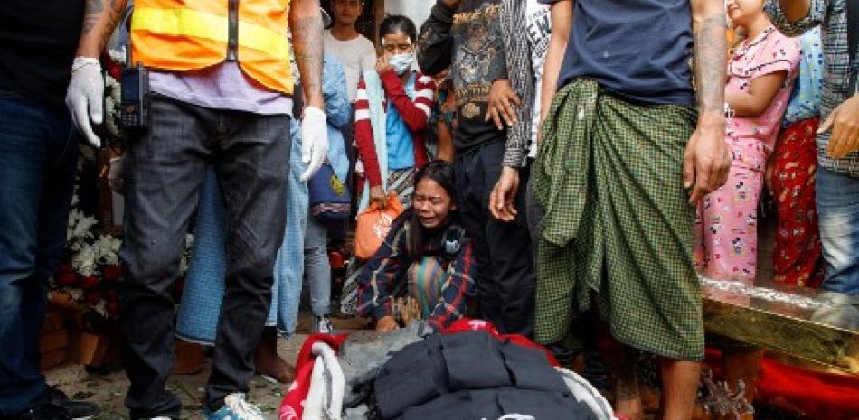 Personas lloran el fallecimiento de otro durante los hechos ocurridos en Birmania. / AFP
