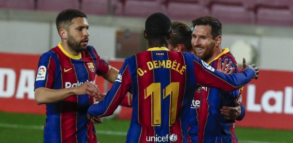 Lionel Messi, a la derecha, celebra con sus compañeros del Barcelona después de anotar el primer gol de su equipo en el encuentro ante el Huesca, el lunes 15 de marzo de 2021, en Barcelona.