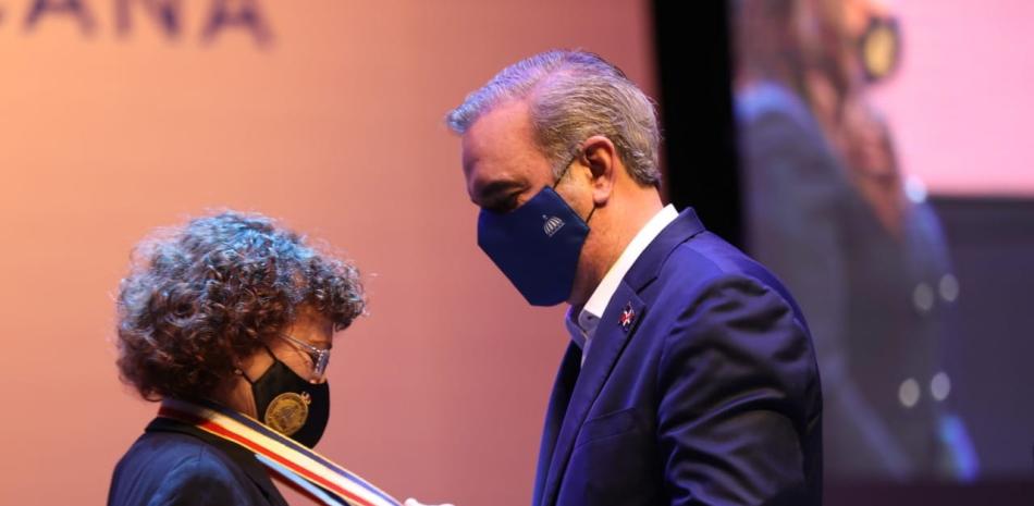 El presidente Luis Abinader mientras imponía la Medalla al Mérito a la profesora Angélica de la Cruz.