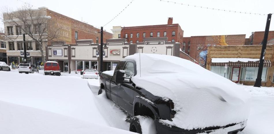 La nieve cubre una camioneta en el centro de Cheyenne, Wyoming, 15 de marzo de 2021. Una intensa tormenta de nieve obligó a cerrar escuelas en partes de Colorado y Wyoming. (Michael Cummo/Wyoming Tribune Eagle via AP)