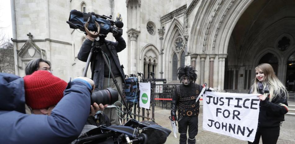 Simpatizantes de Johnny Depp sostienen una pancarta en la que dice "Justicia para Johnny" afuera del Tribunal Supremo en Londres, el jueves 18 de marzo de 2021. (AP Foto/Kirsty Wigglesworth).