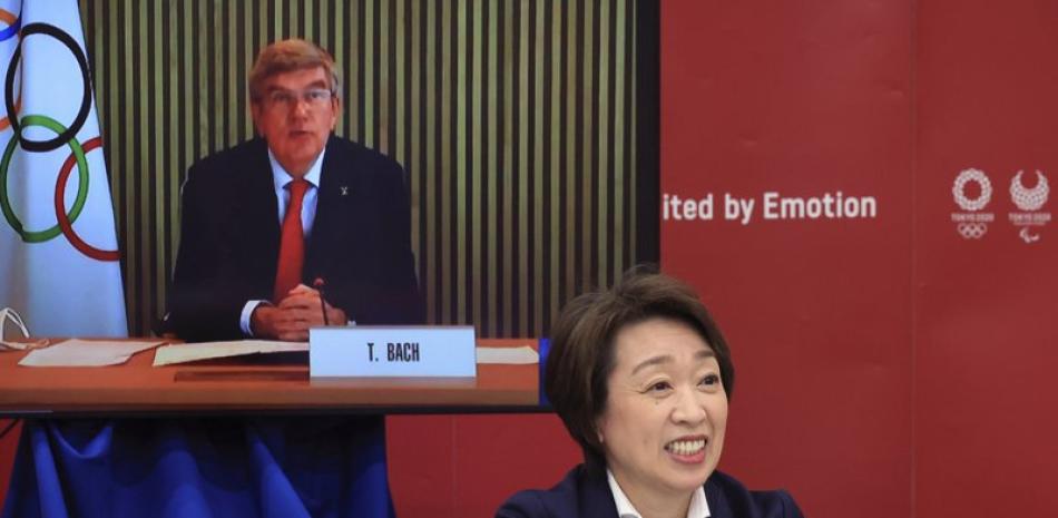 El presidente del COI, Thomas Bach (en una pantalla), interviene en una reunión sobre los Juegos Olímpicos de Tokio 2020, mientras la presidenta del comité organizador, Seiko Hashimoto (en primer plano), escucha sus palabras, en Tokyo, el 20 de marzo de 2021.