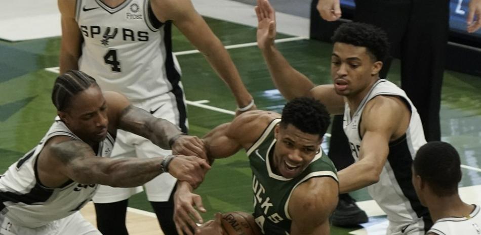 Giannis Antetokounmpo de los Milwaukee Bucks recibe una falta durante la segunda mitad de un juego de baloncesto de la NBA contra los San Antonio Spurs el sábado 20 de marzo de 2021 en Milwaukee.