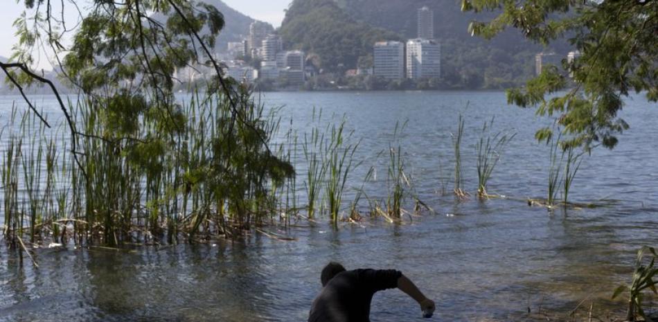 En esta foto del 11 de julio de 2016, el candidato a doctor Rodrigo Staggemeier recoge muestras de agua del lago Rodrigo de Freitas para un estudio sobre la calidad del agua en Río de Janeiro, Brasil.

Foto: AP/Silvia Izquierdo