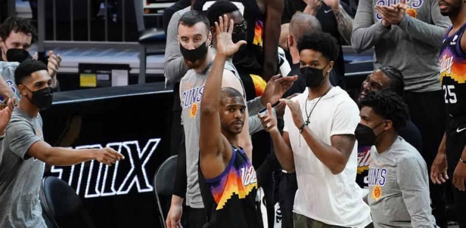 El escolta de los Phoenix Suns,  Chris Paul, celebra con los fanticos luego de arribar a 10 mil asistencias en su carrera, en el partido de domingo ante  Los Angeles Lakers, en Phoenix. (AP Foto/Rick Scuteri)
